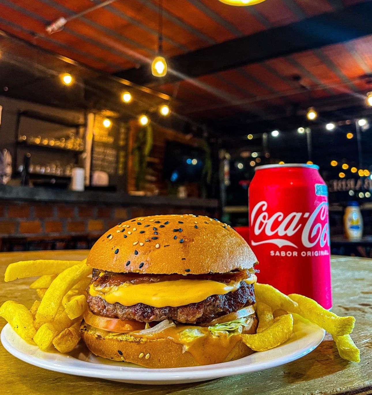 Burger com batata e refrigerante no ambiente da Democrata